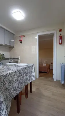a kitchen with a table and a room with a bed at A Toca in Santana