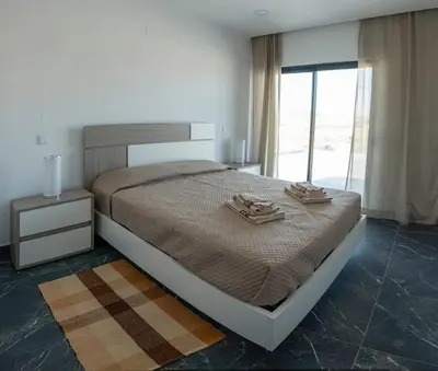 a bedroom with a bed with two towels on it at Sunset House in Vila do Bispo