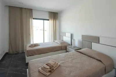 a hotel room with two beds and a window at Sunset House in Vila do Bispo