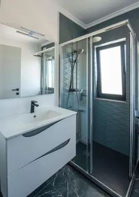 a bathroom with a sink and a glass shower at Sunset House in Vila do Bispo
