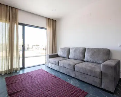 a living room with a couch and a large window at Sunset House in Vila do Bispo
