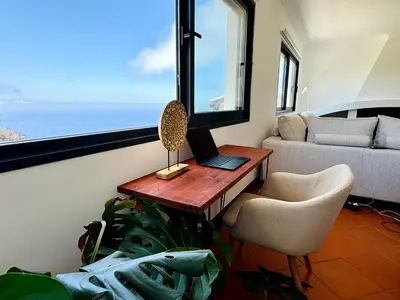 a room with a desk with a computer and a window at Meerblick - 3-Bett Villa mit Terrassen & Hot-Tub in Fajã da Ovelha