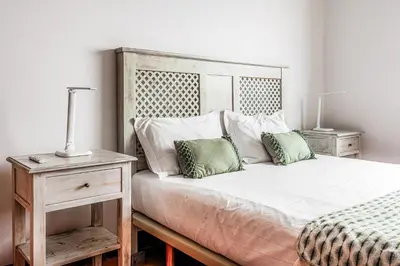 a bedroom with a bed with two night stands and two lamps at Meerblick - 3-Bett Villa mit Terrassen & Hot-Tub in Fajã da Ovelha