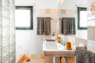 a bathroom with a sink and a mirror at Meerblick - 3-Bett Villa mit Terrassen & Hot-Tub in Fajã da Ovelha