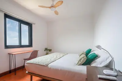 a bedroom with a bed and a ceiling fan at Meerblick - 3-Bett Villa mit Terrassen & Hot-Tub in Fajã da Ovelha
