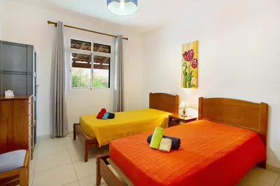 two beds in a room with yellow and orange at Cantinho Solpraia in Porto Santo