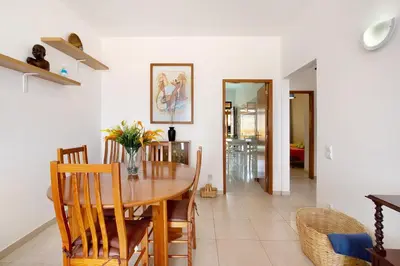 a dining room with a wooden table and chairs at Cantinho Solpraia in Porto Santo