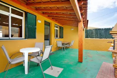 a patio with a white table and chairs on it at Cantinho Solpraia in Porto Santo