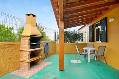 a patio with a fireplace and a table and chairs at Cantinho Solpraia in Porto Santo