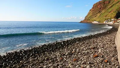 a rocky beach next to the ocean with waves at Blue by the Sea House in Paul do Mar
