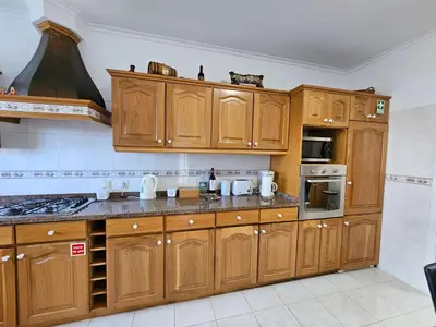 a large kitchen with wooden cabinets and appliances at Casa de Feria do Livramento in Funchal