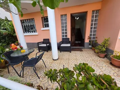 a patio with a table and chairs in front of a building at Casa de Feria do Livramento in Funchal