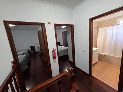 a hallway leading to a bedroom with a tub and a mirror at Casa de Feria do Livramento in Funchal