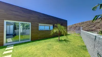 a house with a palm tree in front of it at Villa Blue Horizon by LovelyStay in Tábua