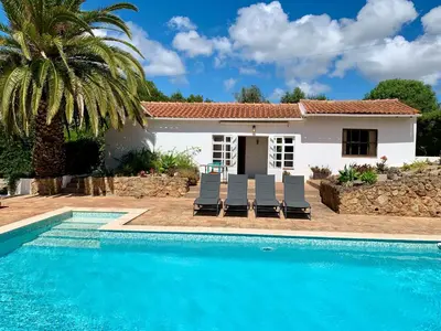 a villa with a swimming pool in front of a house at O Ninho in Atalaia