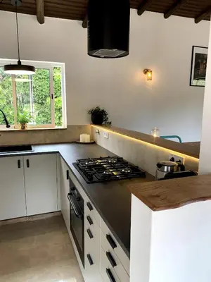a kitchen with white cabinets and a stove top oven at O Ninho in Atalaia