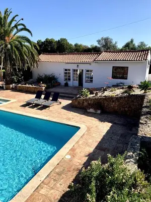 a villa with a swimming pool and a house at O Ninho in Atalaia