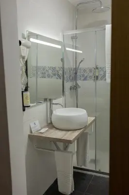 a bathroom with a sink and a glass shower at Flag Hotel Madeira - Ribeira Brava in Ribeira Brava