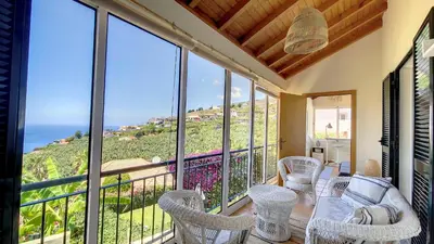 a balcony with a table and chairs and a view of the ocean at Bohome Nest by LovelyStay in Arco da Calheta