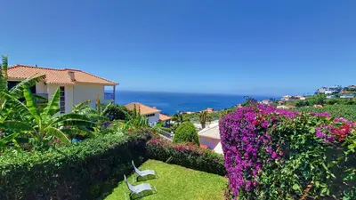 a view of the ocean from a house with flowers at Bohome Nest by LovelyStay in Arco da Calheta