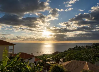 a sunset over the ocean from a city at Bohome Nest by LovelyStay in Arco da Calheta