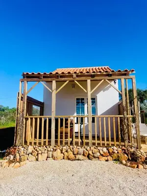 a wooden table with an umbrella next to a swimming pool at Quinta da Bela Vista in Lagos
