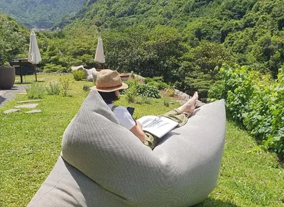 a man laying on a couch in the grass at Terrabona Nature & Vineyards in Boaventura