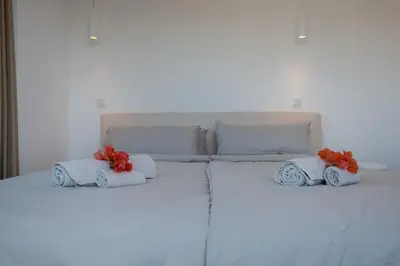 a white bed with towels and flowers on it at GuestReady - A delightful stay in Porto Santo in Pontinhas