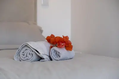 a towel with a flower sitting on a bed at GuestReady - A delightful stay in Porto Santo in Pontinhas
