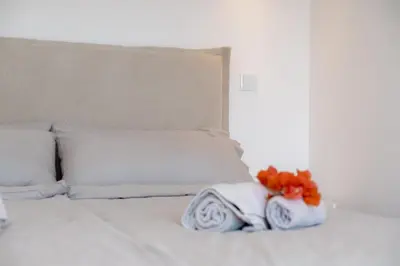 a white bed with white pillows and flowers on it at GuestReady - A delightful stay in Porto Santo in Pontinhas