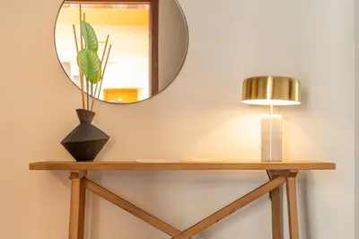 a mirror on a wall next to a table with a lamp at GuestReady - A modern and peaceful stay in Santa Cruz