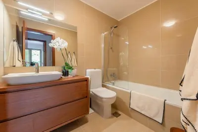 a bathroom with a sink and a toilet and a tub at GuestReady - A modern and peaceful stay in Santa Cruz