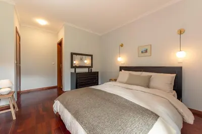 a bedroom with a large bed and a television at GuestReady - A modern and peaceful stay in Santa Cruz