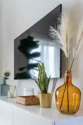 a vase with feathers and a plant on a shelf at Clifftop Nest Arrifana by Lisbeyond in Aljezur