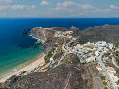 an aerial view of a town on a mountain next to the ocean at Clifftop Nest Arrifana by Lisbeyond in Aljezur
