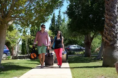 a man and woman walking down a sidewalk with luggage at Villa Lagos Algarve for families & friends, 6 bedrooms, 7 bathrooms, pool, BBQ, central heating in Pedra Alçada