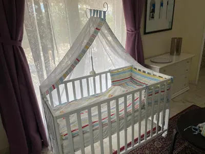 a crib with a canopy in front of a window at Villa Lagos Algarve for families & friends, 6 bedrooms, 7 bathrooms, pool, BBQ, central heating in Pedra Alçada