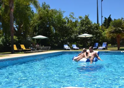 two people are riding on a raft in a swimming pool at Villa Lagos Algarve for families & friends, 6 bedrooms, 7 bathrooms, pool, BBQ, central heating in Pedra Alçada