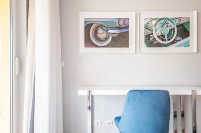 a blue chair in a room with two pictures on the wall at Apartamento Vale Verde by Homie in Funchal