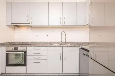 a white kitchen with white cabinets and a sink at Apartamento Vale Verde by Homie in Funchal