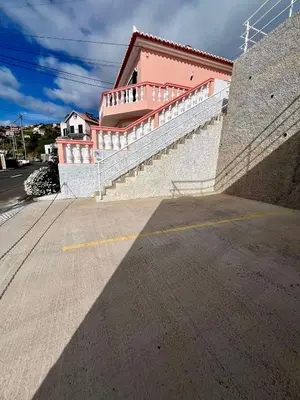 a building with a staircase next to a street at Blue Paradise Apartment in Ribeira Brava