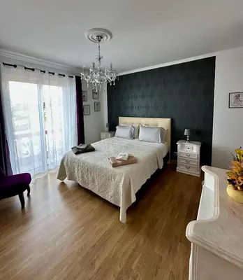 a bedroom with a large bed and a chandelier at Blue Paradise Apartment in Ribeira Brava