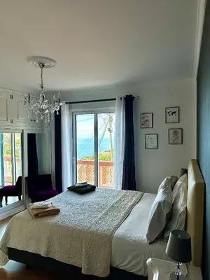 a bedroom with a bed and a large window at Blue Paradise Apartment in Ribeira Brava
