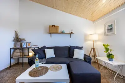 a living room with a blue couch and a table at Casa Ana Mar in Vila do Bispo