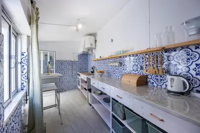 a kitchen with blue and white tiles on the wall at Casa Ana Mar in Vila do Bispo