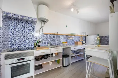 a kitchen with blue and white tiles on the wall at Casa Ana Mar in Vila do Bispo