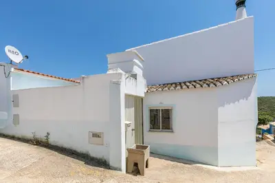 a white building with a bench next to it at Casa Ana Mar in Vila do Bispo