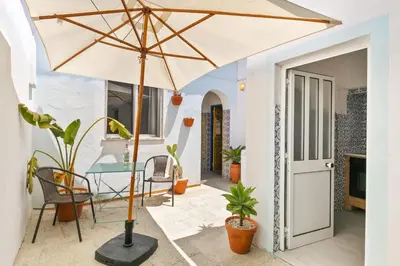 a patio with a table and an umbrella at Casa Ana Mar in Vila do Bispo