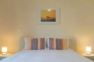 a bedroom with a white bed with two lamps at Calheta Victory View by An Island Apart in Calheta