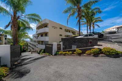 a parking lot in front of a building with palm trees at Calheta Victory View by An Island Apart in Calheta